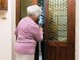 Donna anziana apre la porta