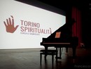 Un pianoforte di fronte alla scritta di Torino Spiritualità