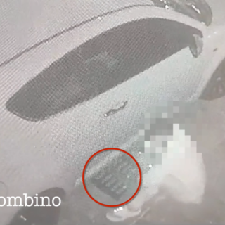 Uomo che preleva un tombino da sotto un'auto parcheggiata