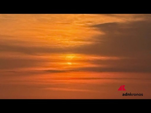 Lo spettacolo dell'eclissi visto dalla spiaggia, sole oscurato dalla luna al tramonto