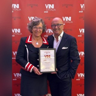 due persone in piedi con un premio in mano